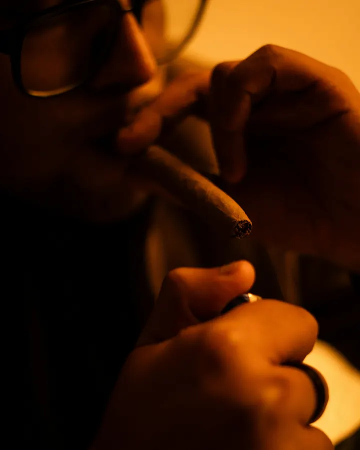 A cigar being lit with a torch lighter